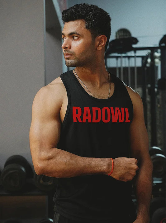 Gym model wearing Radowl Adapt Black Stringer in a gym setting, featuring bold red Radowl print, lightweight slim-fit design, and premium soft cotton fabric for intense workouts in India.