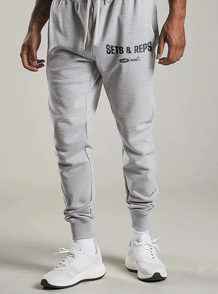 Men wearing grey Sets & Reps gym Joggers for men by Radowl in a gym, showcasing breathable, loose-fit design.