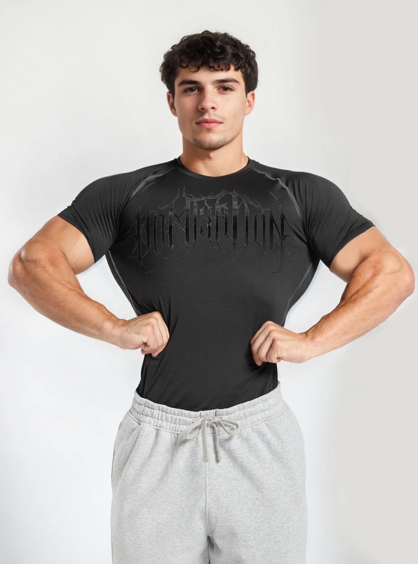 Front image of a fitness model wearing Dark Domination Black half compression tshirt for men standing on whitebackdrop background.