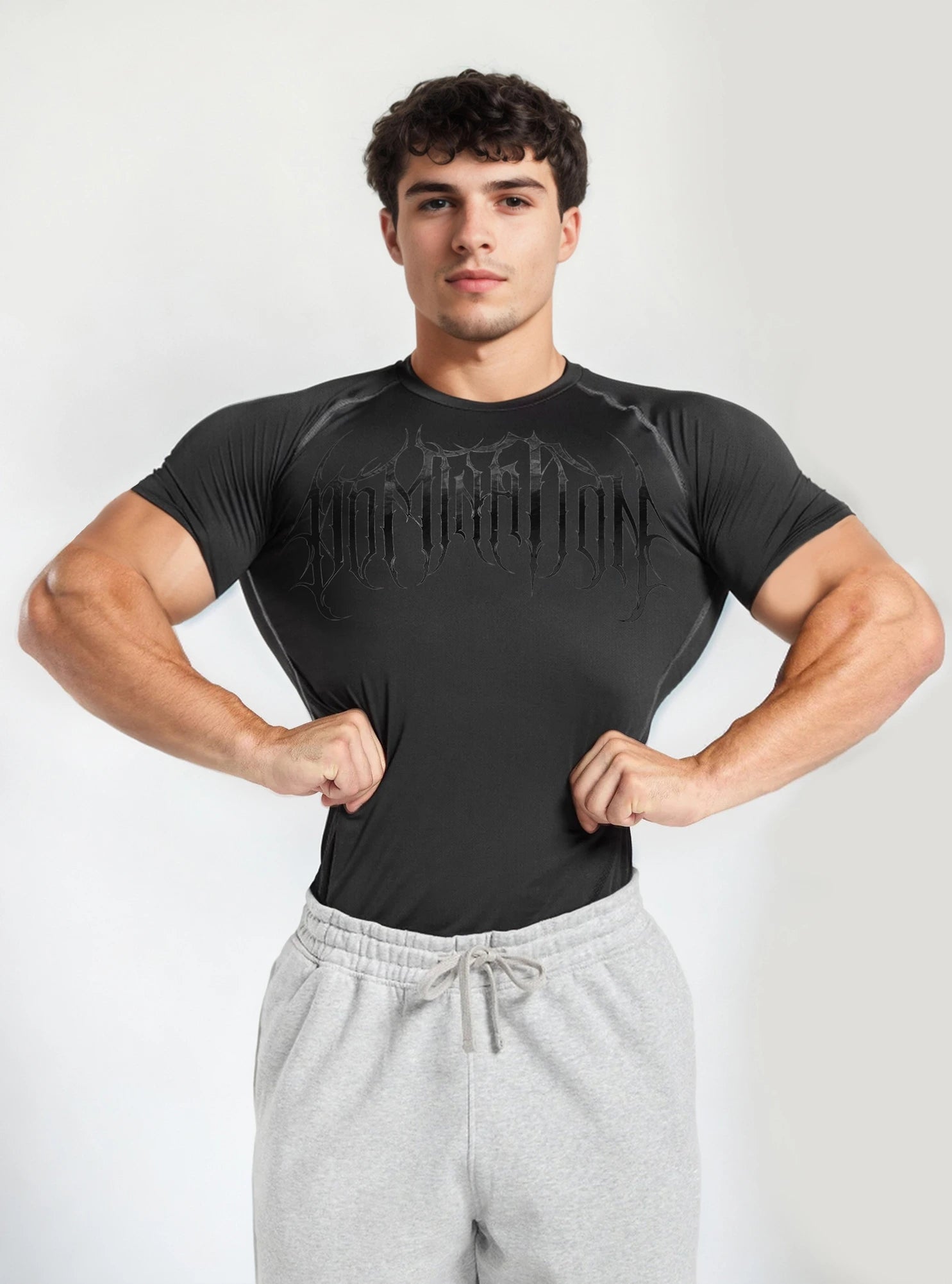 Front image of a fitness model wearing Dark Domination Black half compression tshirt for men standing on whitebackdrop background.